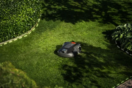 Robotic lawn mower operating in a well-maintained garden.