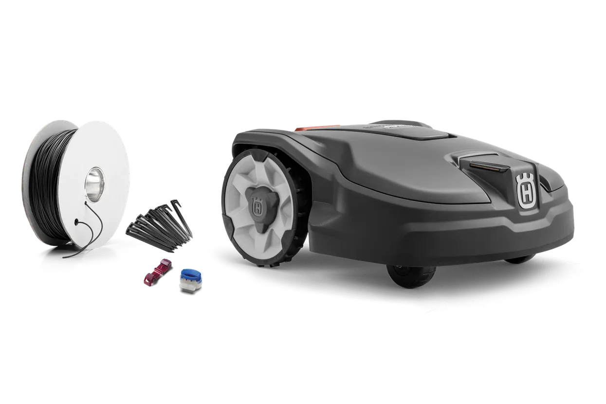 xd-641532.webp Seitenansicht eines Husqvarna Mähroboters mit Installationszubehör einschließlich Begrenzungskabel und Anschlussklemmen.